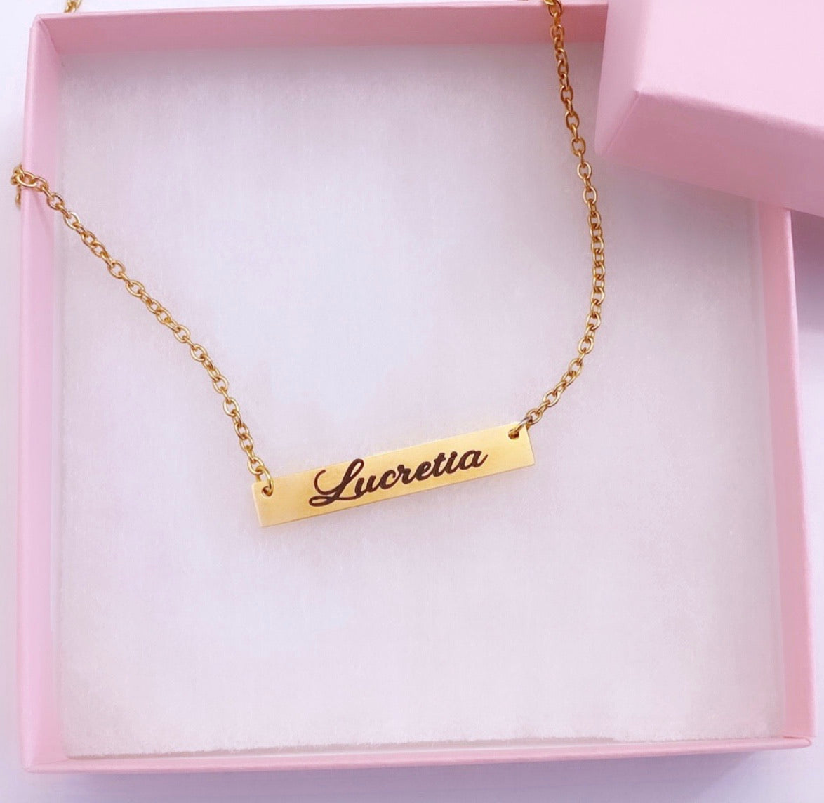Personalized gold engraved nameplate necklace.